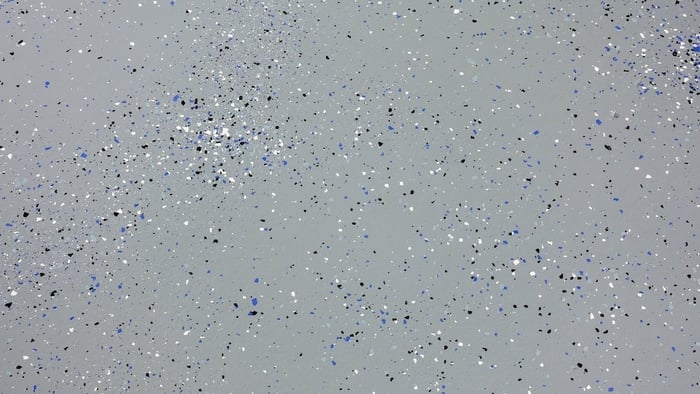 Epoxy coating with blue, white, and black color chips installed on concrete floor