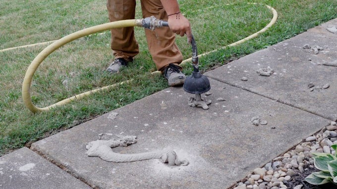 Pumping limestone slurry grout under settled sidewalk