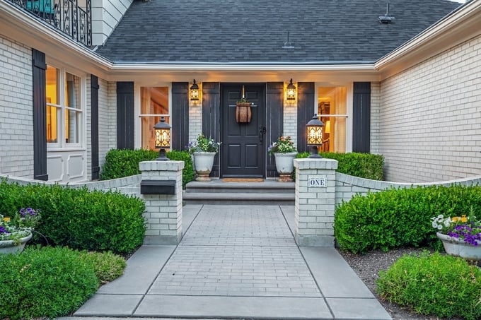 Brick ranch home with concrete walkway leading up to porch