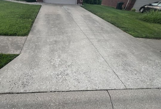 Two-car concrete driveway with discoloration and spalling