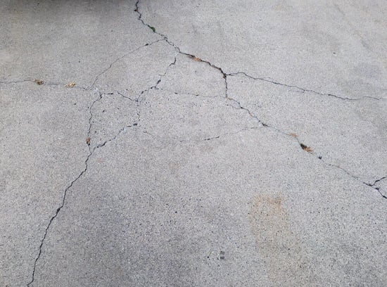 Concrete driveway with cracks running through it