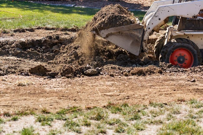 Small bulldozer digging in yard