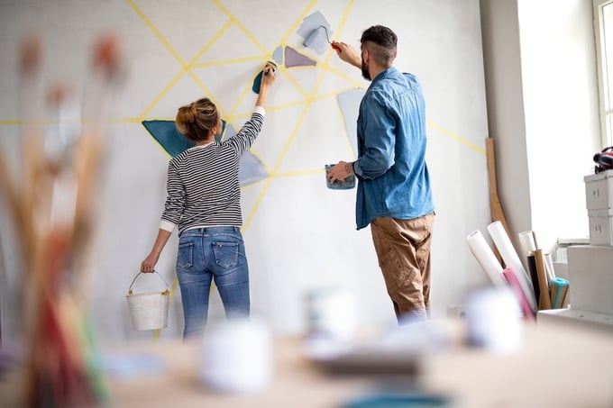 Couple painting interior wall