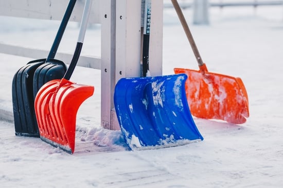 Plastic snow shovels leaned up against fence post