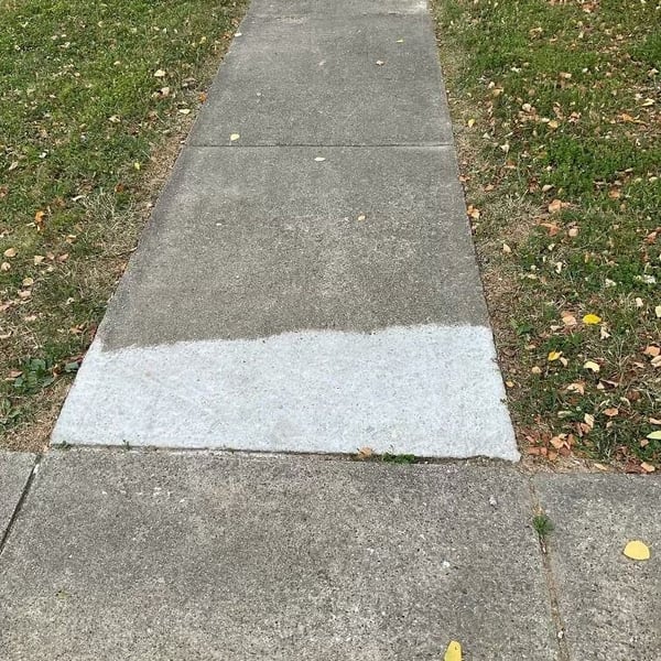 Sidewalk slab next to driveway ground down to eliminate trip hazard