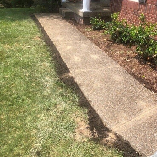 Soil added to the edges of a walkway leading to a front porch