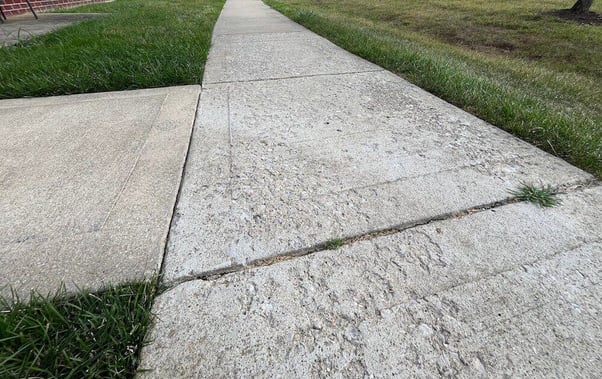 Concrete surface spalling on sidewalk slabs