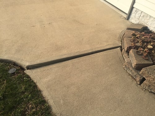 Trip hazard near concrete driveway and walkway