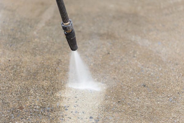 Wand pressure washer cleaning concrete