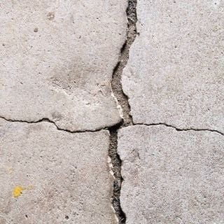 Concrete slab with large cracks running through it