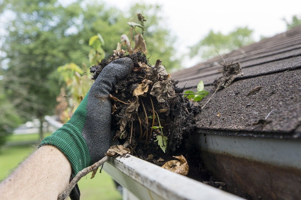 Cleaning debris from clogged gutters